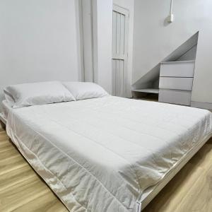 a white bed in a white bedroom with a staircase at Moon House Granada in Estación El Salto
