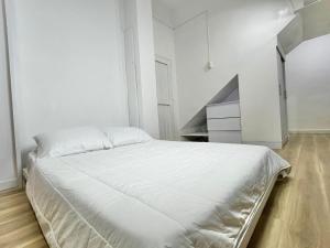 a white bedroom with a large white bed in it at Moon House Granada in Estación El Salto