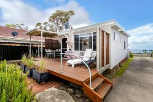 Casa con terraza con mesa y sillas en Osprey - Pet Friendly Waterfront, en Callala Bay