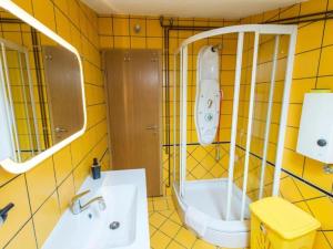 Baño de azulejos amarillos con lavabo y aseo en Two-Bedroom Apartment With Lake View, en Bara 63 fotos más