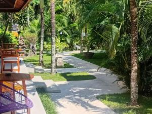 a path through a park with palm trees at Nature's Immersion Room at Anwa Bali Boutique Resort in Canggu