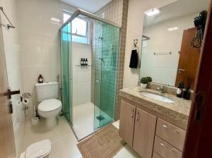 Un baño con inodoro y ducha de cristal. en Apartamento em região central com 3 smart TVs - UFV a 1 km, en Viçosa
