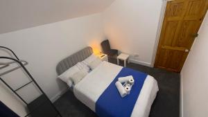 Dormitorio pequeño con cama con manta azul en Pat Signature STAYS, en Kingsthorpe