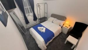 un pequeño dormitorio con una cama con un osito de peluche. en Pat Signature STAYS, en Kingsthorpe