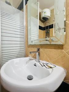 a bathroom with a white sink and a mirror at نزل الزائر 2 in Medina