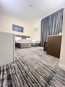 a hotel room with two beds and a window at نزل الزائر 2 in Medina