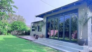 a house with a porch with glass doors at Modern Retreat with Stylish Interiors & Peaceful Garden View in Bloemfontein