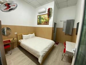 a small room with a bed and a desk and a bed sidx sidx at Hotel Sơn Duyên in Ấp Thiện Lập