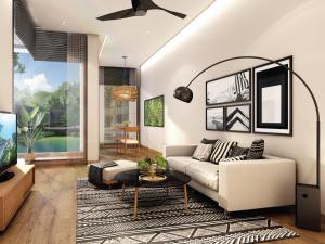 a living room with a couch and a tv at MontAzure Resort Phuket - MGallery Collection in Phuket Town