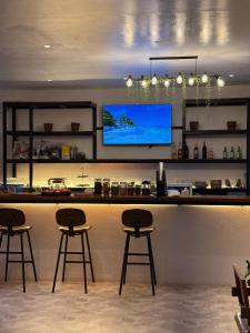a bar with two stools and a flat screen tv at Isa- Hostel in Panglao