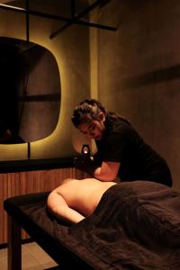 a woman sitting in a bed in a room with a mirror at Nature's Immersion Room at Anwa Bali Boutique Resort in Canggu +11 photos