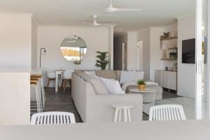 un salon blanc avec un canapé et une table dans l'établissement Surfrider Hideaway - steps to beach, à Mudjimba