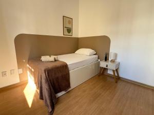 Un dormitorio con una cama con una manta encima. en Apartamento em região central com 3 smart TVs - UFV a 1 km, en Viçosa