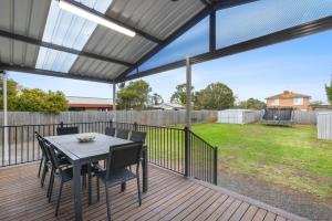 Un patio con una mesa y sillas en una terraza. en Seabreeze Retreat, en Portarlington