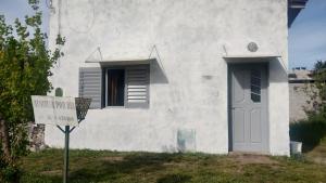 a white house with a sign in front of it at La esquina in Olavarría