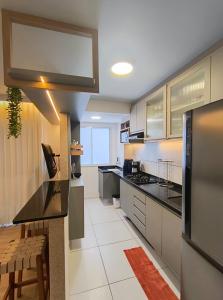 a kitchen with black counter tops and cabinets and a counter top at Solar Aruana, Aracaju, Aeroporto, Orla de Atalaia e Praia in Aracaju