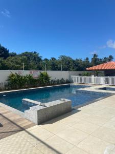 a swimming pool with a bench in the middle at Solar Aruana, Aracaju, Aeroporto, Orla de Atalaia e Praia in Aracaju