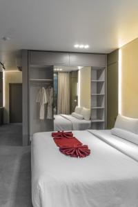 Una gran cama blanca con un vestido rojo. en XO Canggu adults only, en Canggu