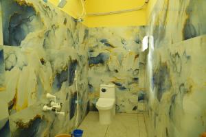 une salle de bain avec toilettes et un tableau au mur dans l'établissement Seawave Beach Resort, à Bahūr 38 autres photos