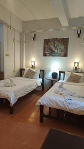 a room with two beds and a table with lights at The Sunshine hostel and hotel in Ko Lanta +55 photos
