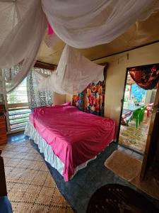 - une chambre avec un lit rouge à baldaquin dans l'établissement Yavu room, à Rakiraki
