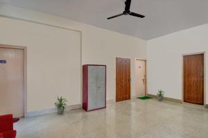 a room with two doors and a ceiling fan at Hotel O Tumpa Inn in Kolkata