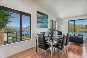 a dining room with a table and chairs and large windows at Magical views Perfect place to stay in Frankton Wharf