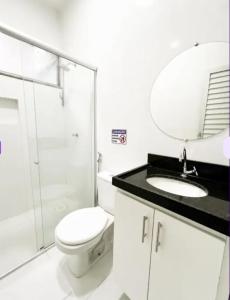 une salle de bain avec toilettes, lavabo et miroir dans l'établissement Pousada Elizondo 06, à Belém