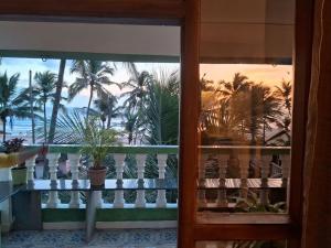 阿贡达Cupid's Heaven Resort的棕榈树阳台享有海滩美景。