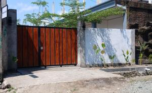 a wooden gate in front of a house at Pandava House Lombok in Lombok International Airport