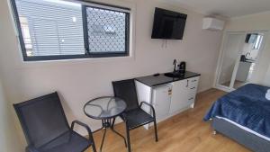 a bedroom with a bed and a table and chairs at Guyra Club Cabins in Guyra +8 photos