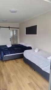 a room with two beds and a flat screen tv at Guyra Club Cabins in Guyra