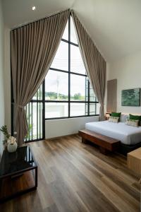 a bedroom with a bed and a large window at New Algaea Pool Villa 3BR Jacuzzi - Krabi Ao Nang in Ban Khlong Haeng