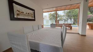 a bedroom with a white bed with a picture on the wall at Casa de las Nueces in Cieneguilla