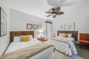 a bedroom with two beds and a ceiling fan at Sands of Kahana 354 · SK 354 Updated Maui OceanFront 2BD w Ocean in Kahana +42 photos