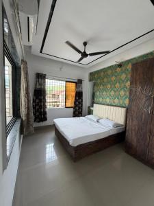 a bedroom with a large bed with a ceiling at SWARAGAN HOLIDAYS VILLA 4 BHK AC LUXURY Room private pool in Lonavala