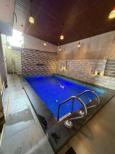 a large swimming pool with blue water in a building at SWARAGAN HOLIDAYS VILLA 4 BHK AC LUXURY Room private pool in Lonavala