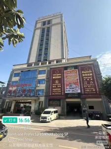 un edificio con un coche aparcado delante en 老挝贵庭湖南大酒店, en Vientiane