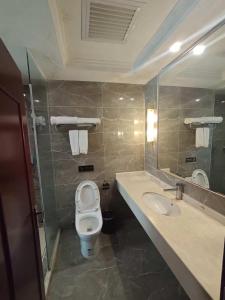 un baño con inodoro y lavabo en 老挝贵庭湖南大酒店, en Vientiane 15 fotos más