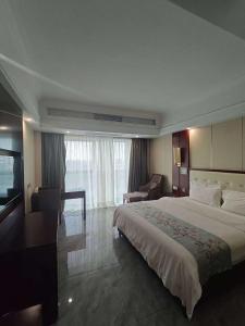 Una habitación de hotel con una cama grande y un escritorio. en 老挝贵庭湖南大酒店, en Vientiane