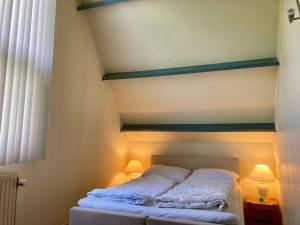 un lit avec deux oreillers dessus dans une chambre dans l'établissement 6 pers - Modern holiday home with garden, close the Lauwersmeer, à Oostmahorn