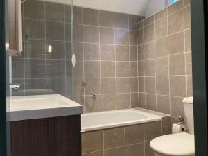 une salle de bain avec une baignoire, un lavabo et des toilettes dans l'établissement 6 pers - Modern holiday home with garden, close the Lauwersmeer, à Oostmahorn 29 autres photos