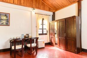 a dining room with a table and chairs and a window at Treasure Heritage Luang Prabang Hotel in Luang Prabang