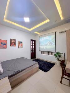 een slaapkamer met een bed en een projectiescherm bij Lamoon Villa in Thôn Dương Xuân Hạ