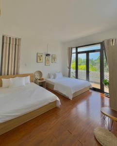 een slaapkamer met twee bedden en een groot raam bij Lamoon Villa in Thôn Dương Xuân Hạ
