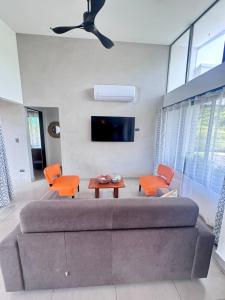 a living room with a large couch and orange chairs at Casa Bella 3 Bdrm House w Pool in Gated Community in Marbella
