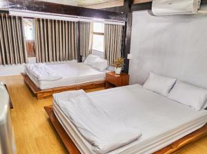 une chambre avec deux lits et une fenêtre dans l'établissement Homestay Shangri- La, à Ấp Sung Xuân