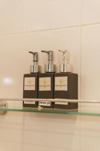 a shelf with three bottles of shaver oil on it at Treasure Heritage Hotel in Luang Prabang