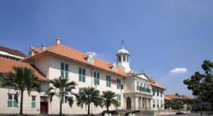 a large building with palm trees in front of it at Hotel Mutiara Kota Tua in Jakarta +16 photos