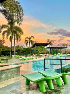 a pool at a resort with a green bench next to it at Casa Bella 3 Bdrm House w Pool in Gated Community in Marbella